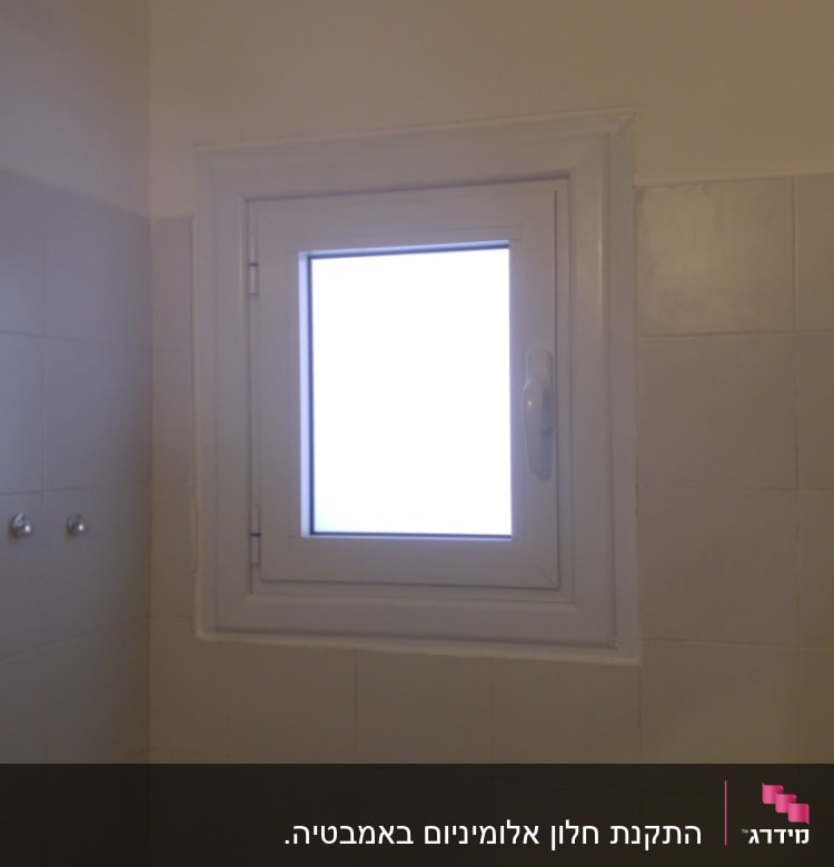 חלון אלומיניום עם מסגרת לבנה וקיר אריחים